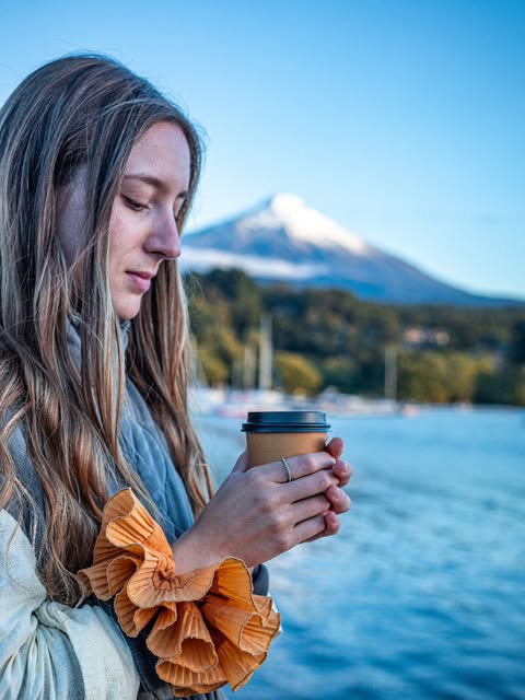 Café frente al volcán nevado con coleta mostaza en la muñeca