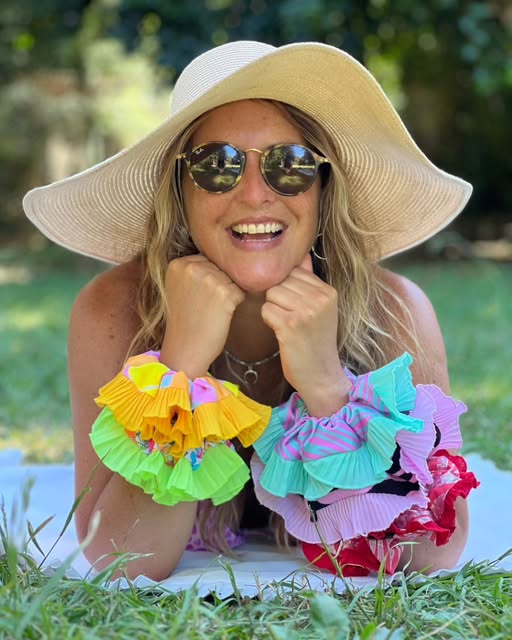 Mujer con sombrero luciendo coletas multicolores en las muñecas